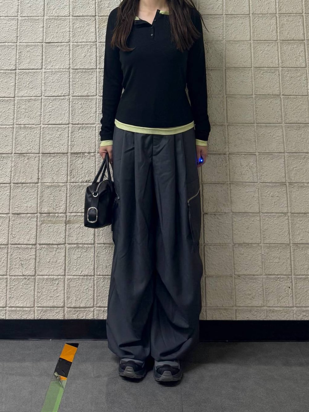 グレー系のカーゴパンツ、ブラック系のTシャツ/カットソー、ブラック系のショルダーバッグを着用したレディースの秋コーディネートの2枚目の写真