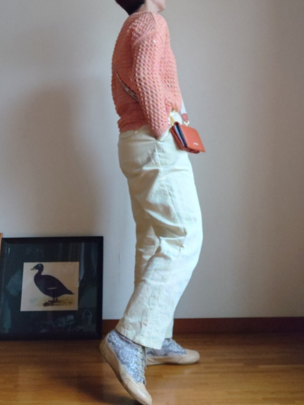 ピンク系のトップス、オレンジ系のショルダーバッグ、イエロー系のスラックスを着用したレディースの春コーディネートの2枚目の写真