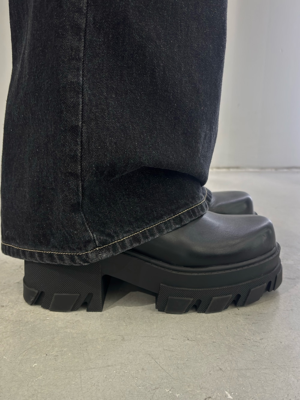 ブラック系のニット/セーター、ブルー系のデニムパンツ、ブラック系のブーツを着用したレディースの冬コーディネートの5枚目の写真