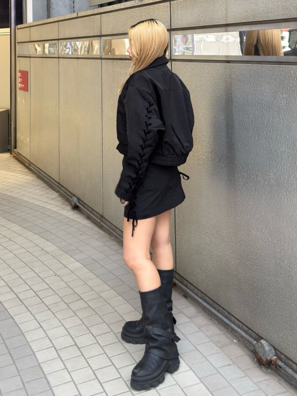 ブラック系のブーツ、ブラック系のスカート、ブラック系のブルゾンを着用したレディースの冬コーディネートの2枚目の写真