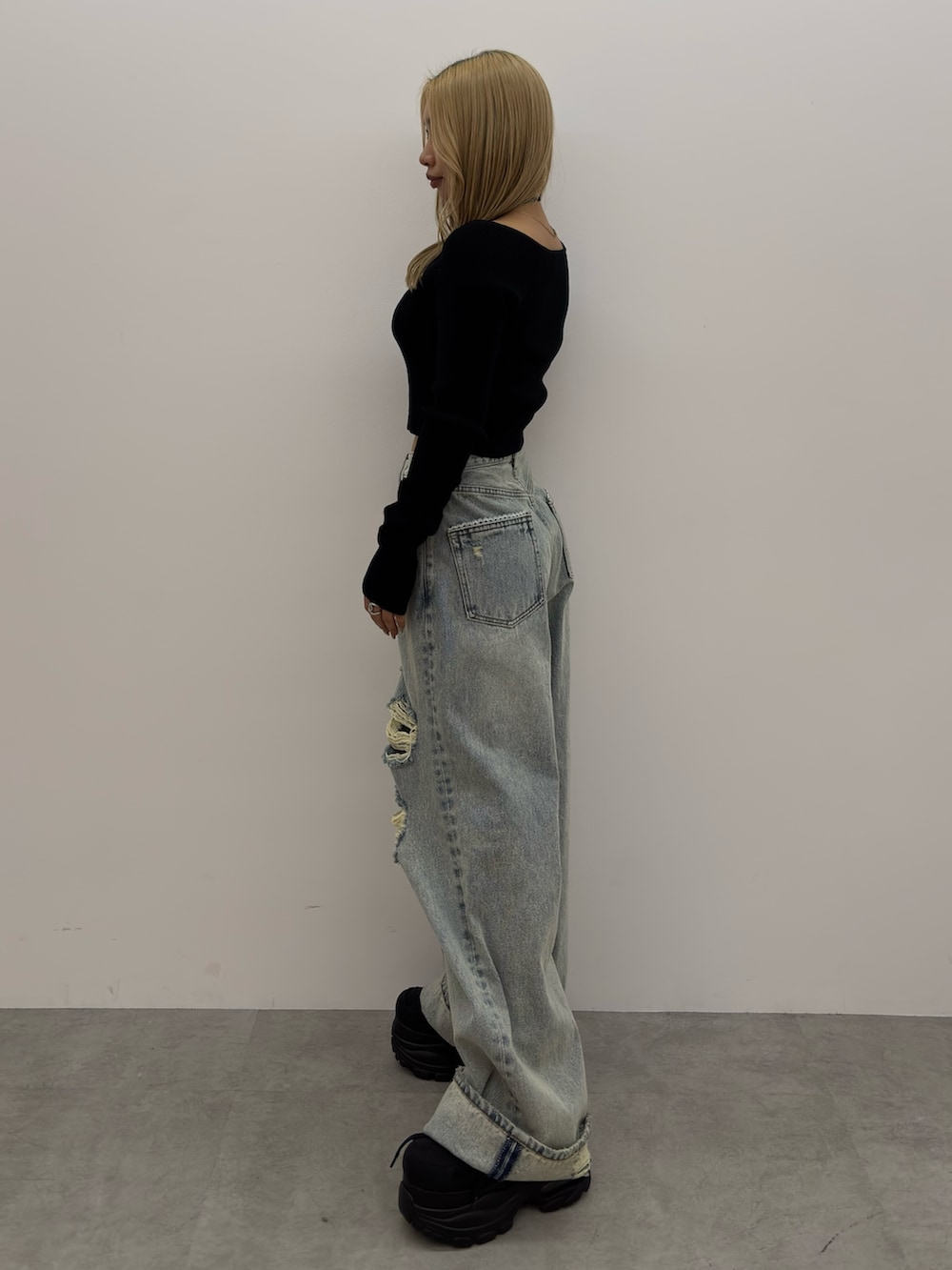 ブラック系のニット/セーター、ブルー系のデニムパンツ、ブラック系のスニーカーを着用したレディースの冬コーディネートの2枚目の写真