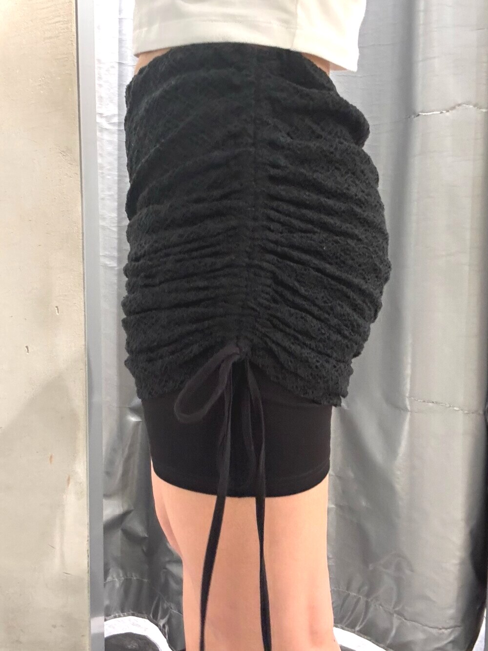 ブラック系のサンダル、ホワイト系のTシャツ/カットソー、ブラック系のスカートを着用したレディースの夏コーディネートの6枚目の写真