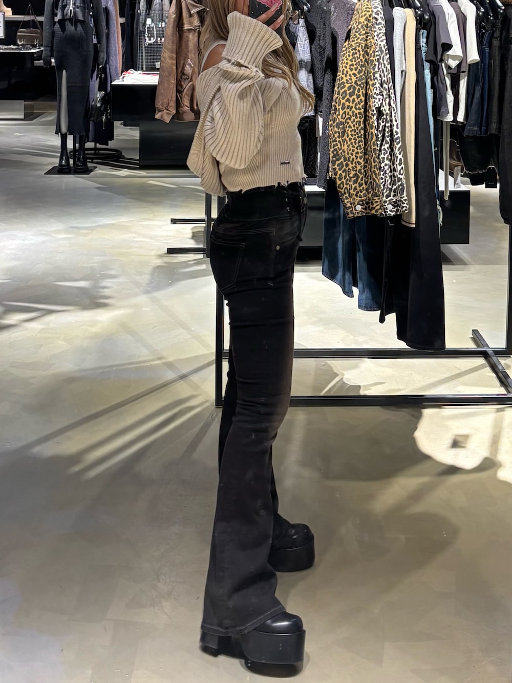 ホワイト系のニット/セーター、ブラック系のデニムパンツ、ブラック系のブーツを着用したレディースの秋コーディネートの2枚目の写真