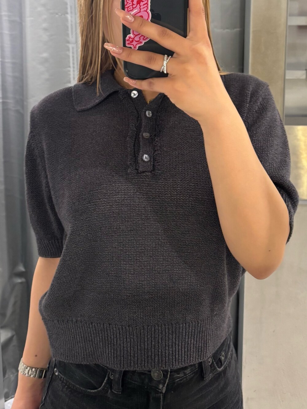 ブラック系のデニムパンツ、ブラック系のニット/セーター、ブラック系のパンプスを着用したレディースの夏コーディネートの4枚目の写真