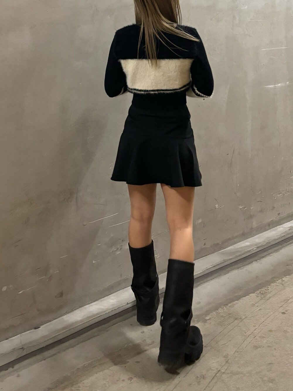 ブラック系のニット/セーター、ブラック系のスカート、ブラック系のブーツを着用したレディースの冬コーディネートの3枚目の写真