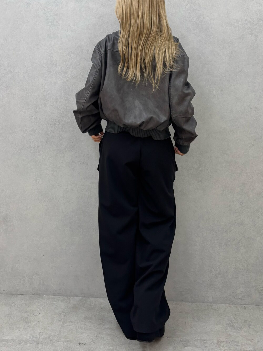 グレー系のブルゾン、ブラック系のその他パンツ、ブラック系のブーツを着用したレディースの秋コーディネートの3枚目の写真