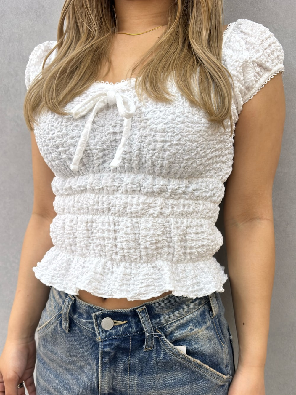 ホワイト系のTシャツ/カットソー、ブルー系のデニムパンツ、ホワイト系のサンダルを着用したレディースの春コーディネートの4枚目の写真