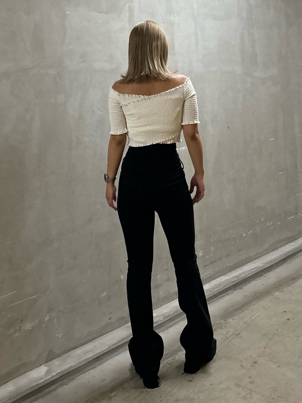ブラック系のデニムパンツ、ホワイト系のTシャツ/カットソー、ブラック系のサンダルを着用したレディースの夏コーディネートの3枚目の写真