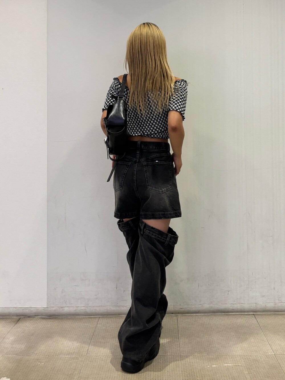 ブラック系のスニーカー、グレー系のTシャツ/カットソー、ブラック系のハンドバッグを着用したレディースの夏コーディネートの3枚目の写真