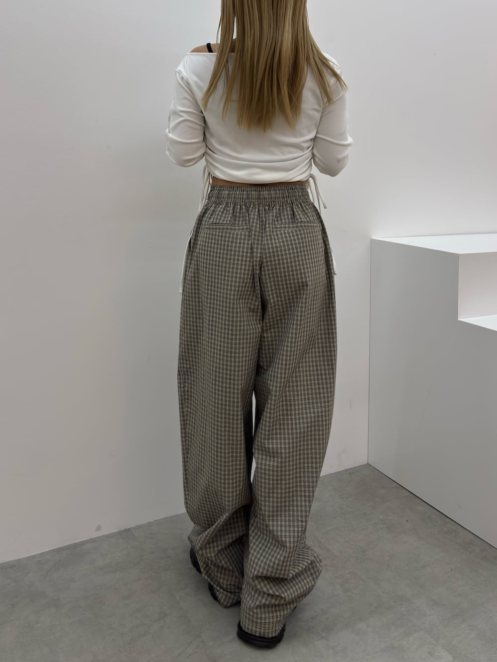 ホワイト系のTシャツ/カットソー、ベージュ系のその他パンツ、ブラック系のスニーカーを着用したレディースの春コーディネートの3枚目の写真