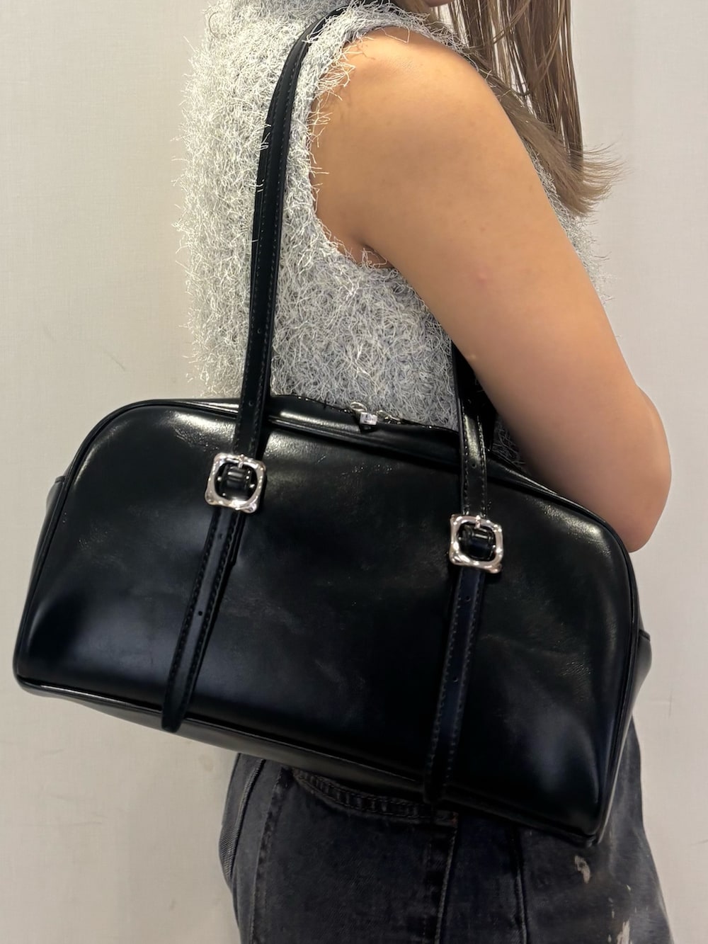 ブラック系のパンプス、ブラック系のデニムパンツ、グレー系のニット/セーターを着用したレディースの春コーディネートの6枚目の写真