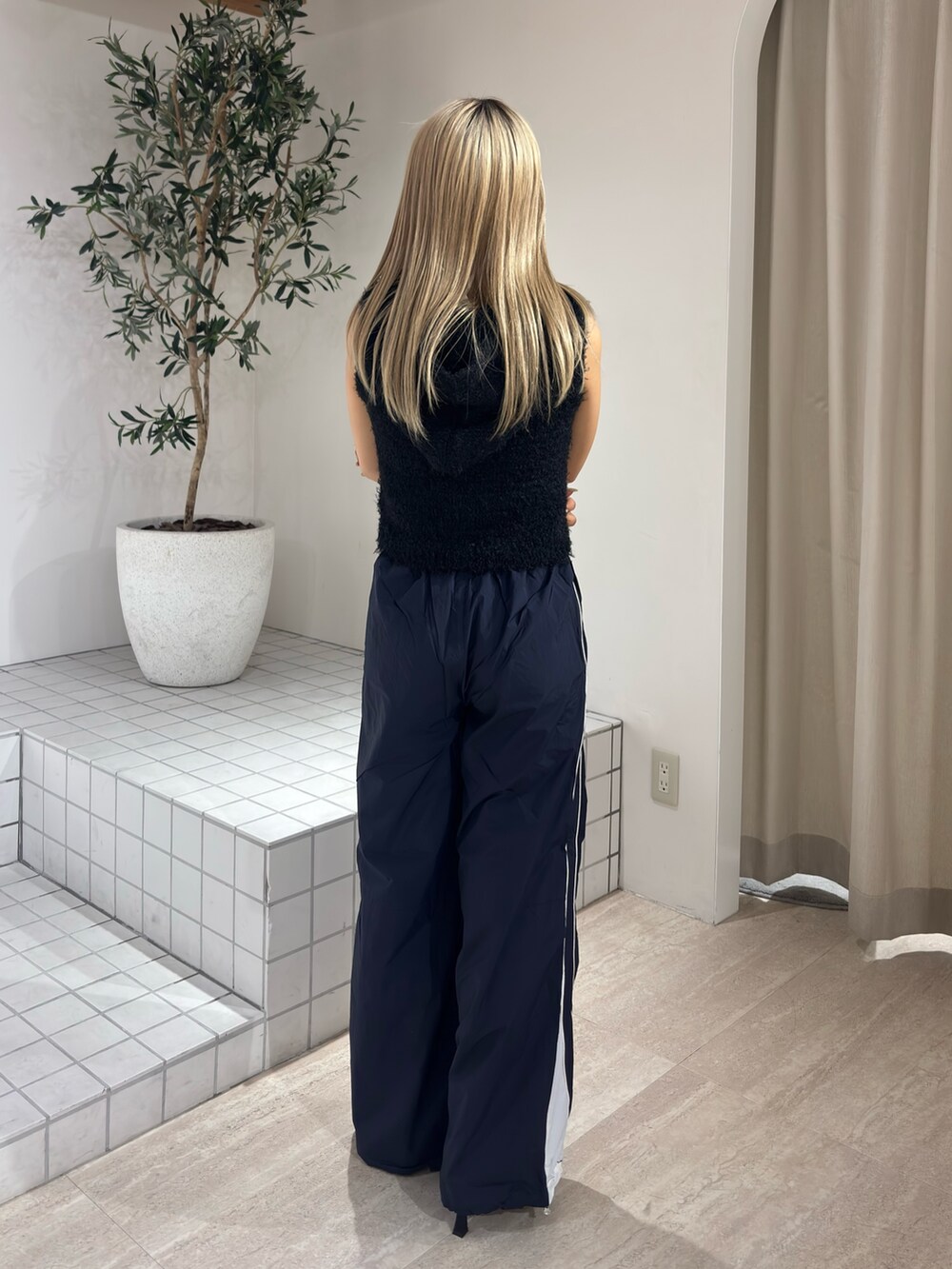 ブラック系のニット/セーター、ブルー系のその他パンツ、ブラック系のパンプスを着用したレディースの春コーディネートの3枚目の写真