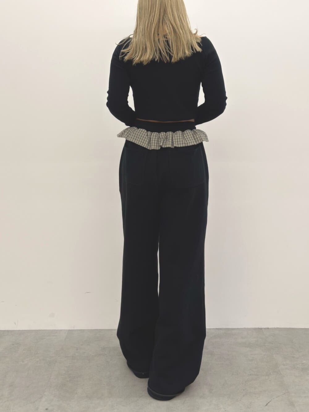 ブラック系のスウェットパンツ、ブラック系のスニーカー、ブラック系のTシャツ/カットソーを着用したレディースの冬コーディネートの3枚目の写真