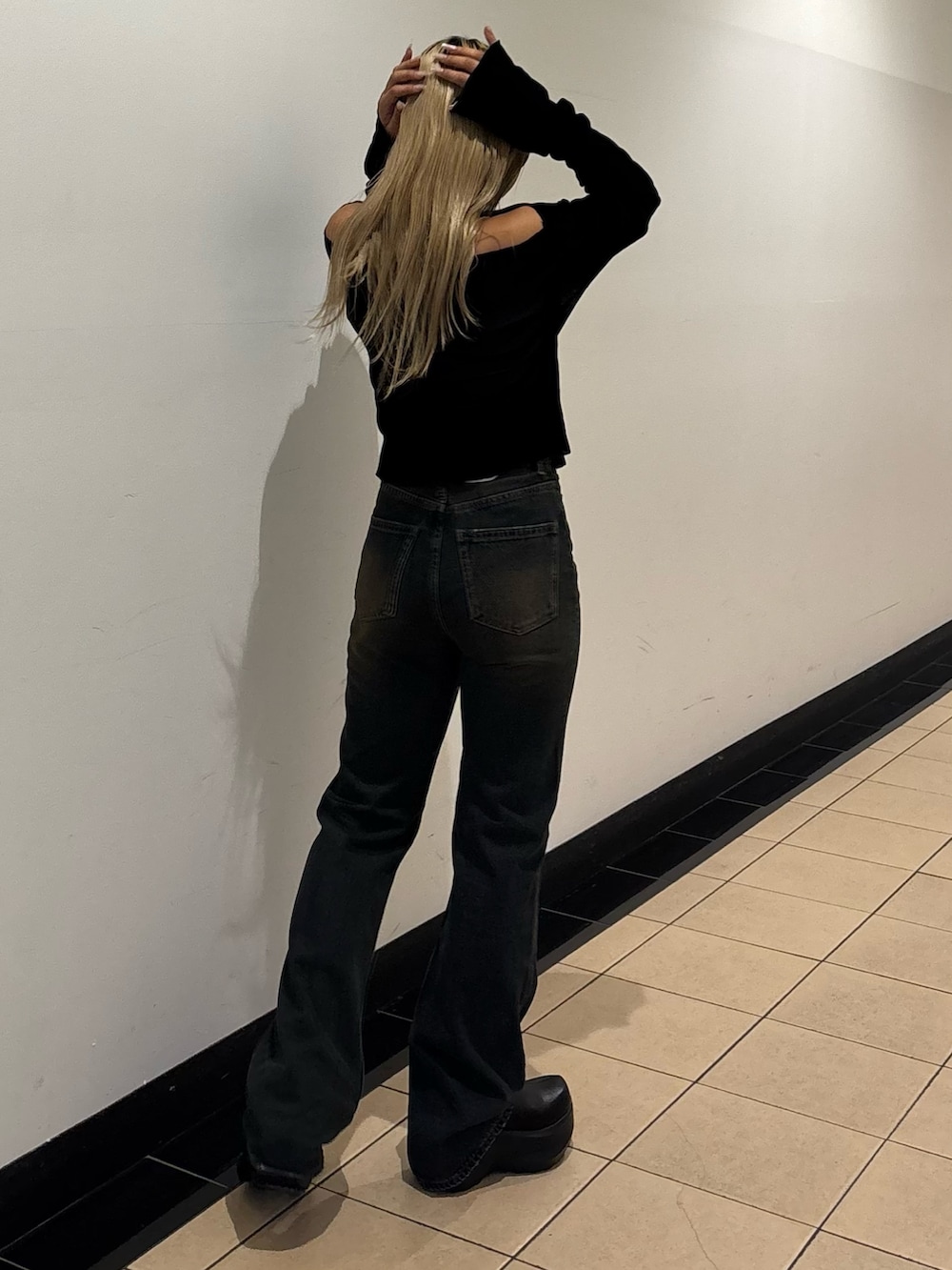 ブルー系のデニムパンツ、ブラック系のスリッポン、ブラック系のTシャツ/カットソーを着用したレディースの秋コーディネートの3枚目の写真