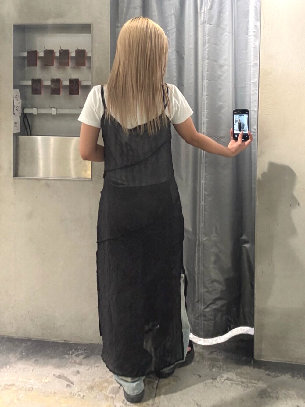 ブラック系のサンダル、ブラック系のワンピース、ホワイト系のTシャツ/カットソーを着用したレディースの夏コーディネートの3枚目の写真