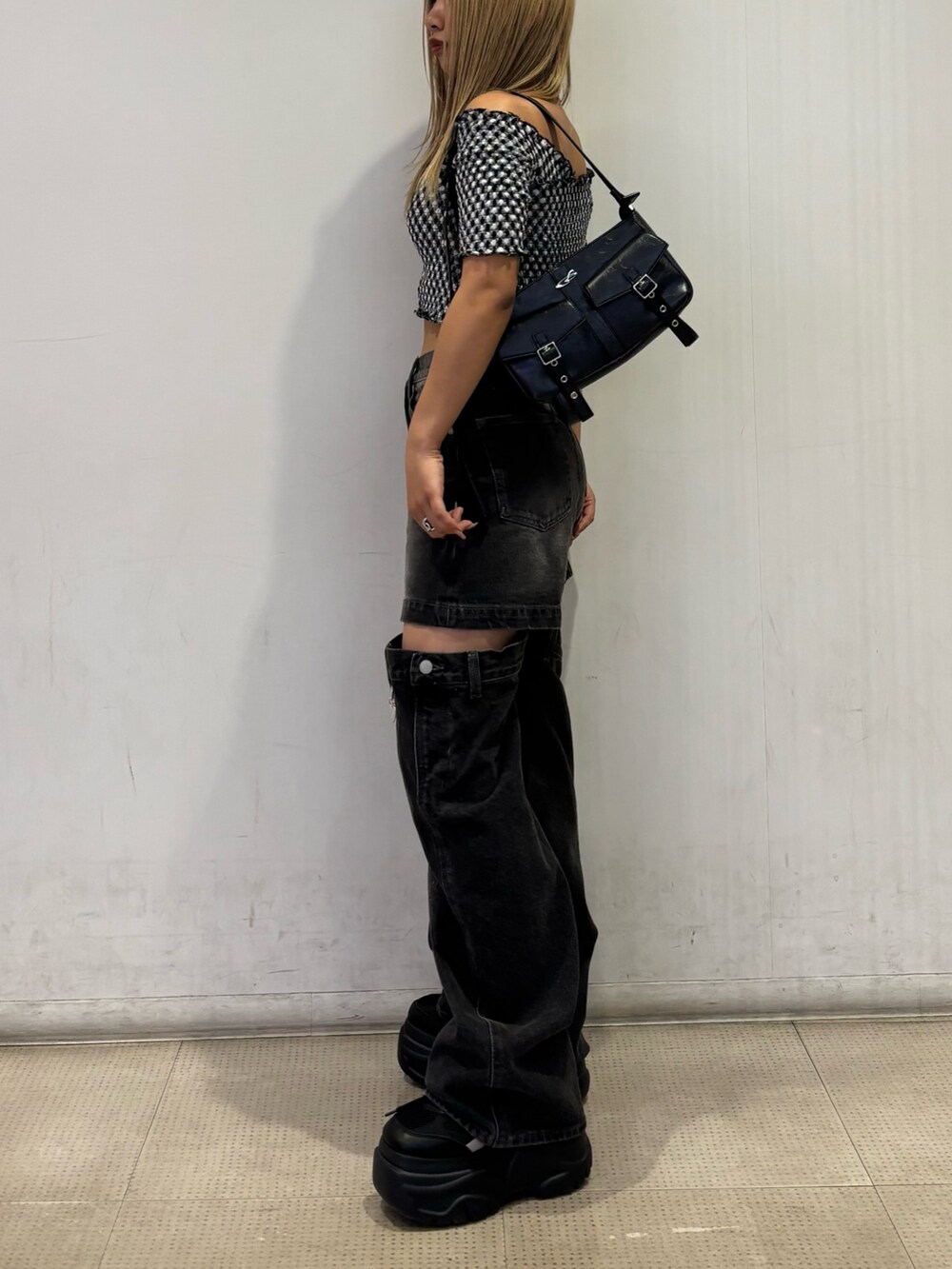 ブラック系のスニーカー、グレー系のTシャツ/カットソー、ブラック系のハンドバッグを着用したレディースの夏コーディネートの2枚目の写真