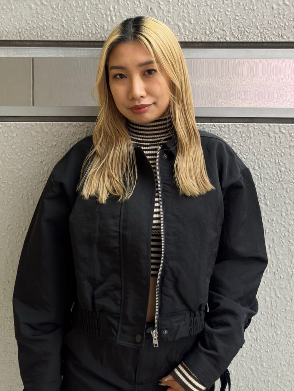 ブラック系のブーツ、ブラック系のスカート、ブラック系のブルゾンを着用したレディースの冬コーディネートの4枚目の写真