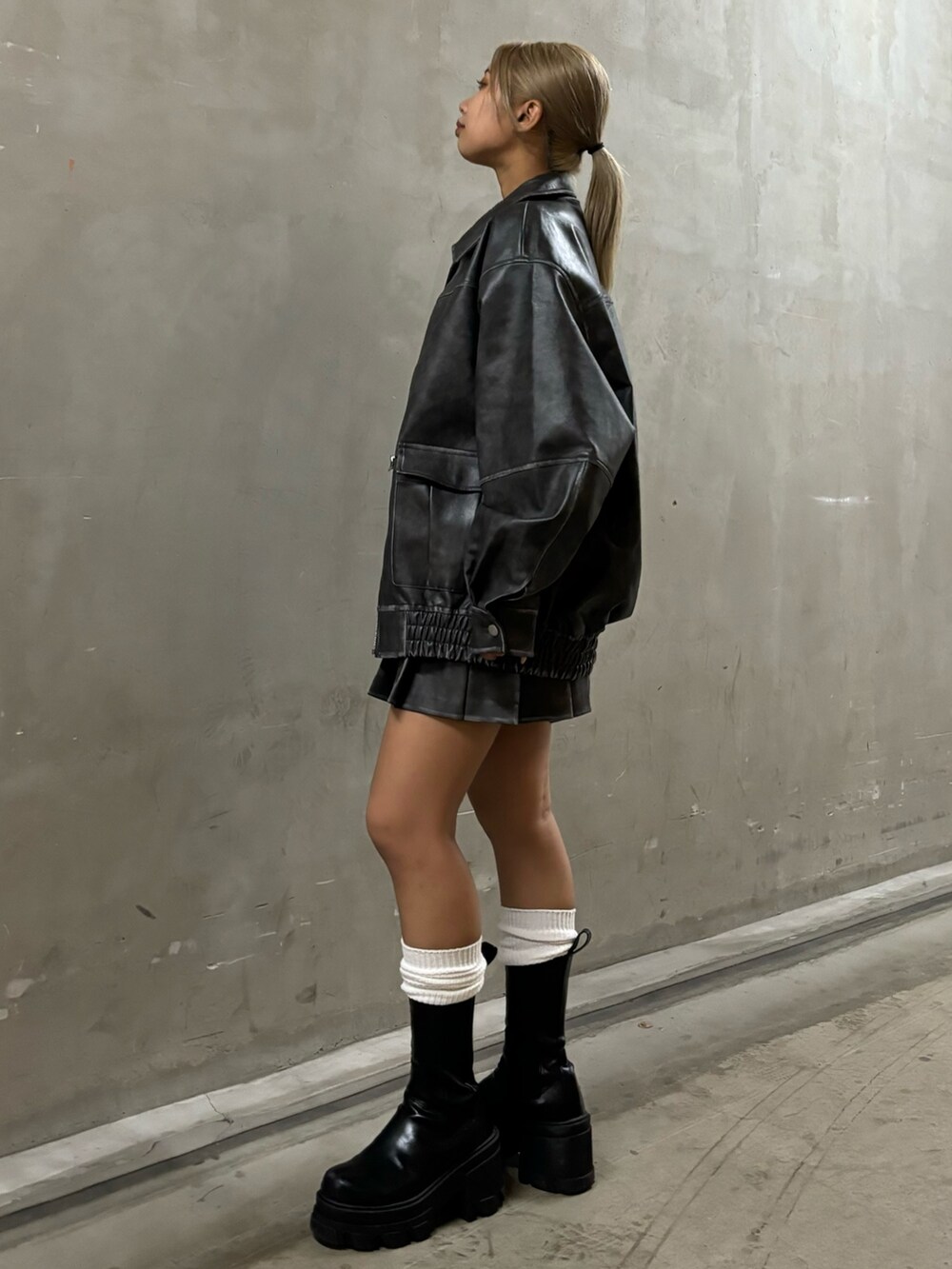 ブラック系のブーツ、グレー系のスカート、ブラック系のTシャツ/カットソーを着用したレディースの夏コーディネートの2枚目の写真