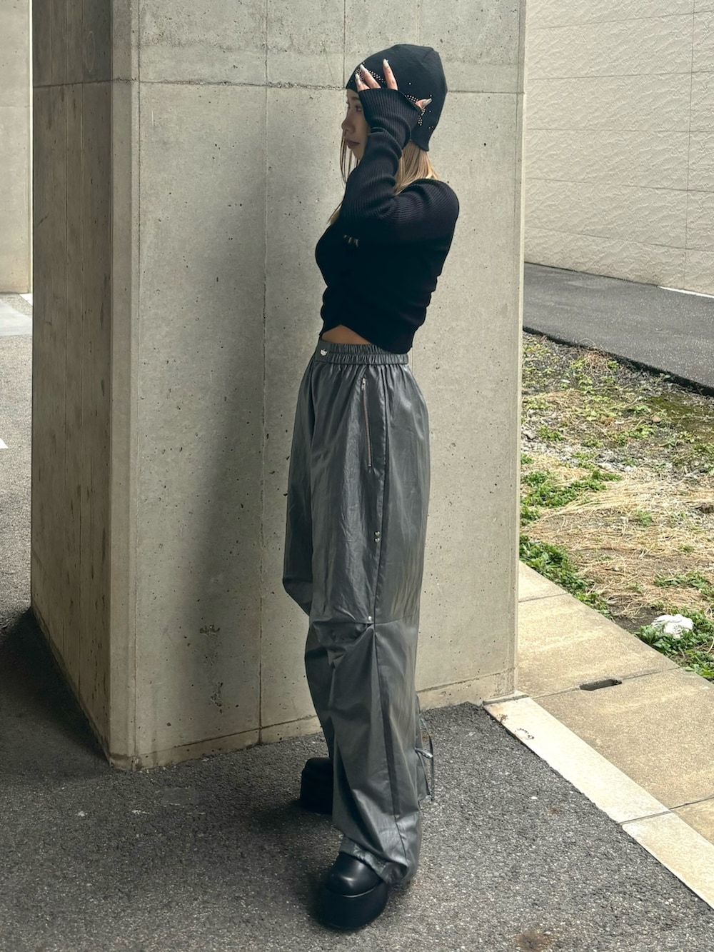 グレー系のその他パンツ、ブラック系のニット/セーター、ブラック系のブーツを着用したレディースの冬コーディネートの2枚目の写真