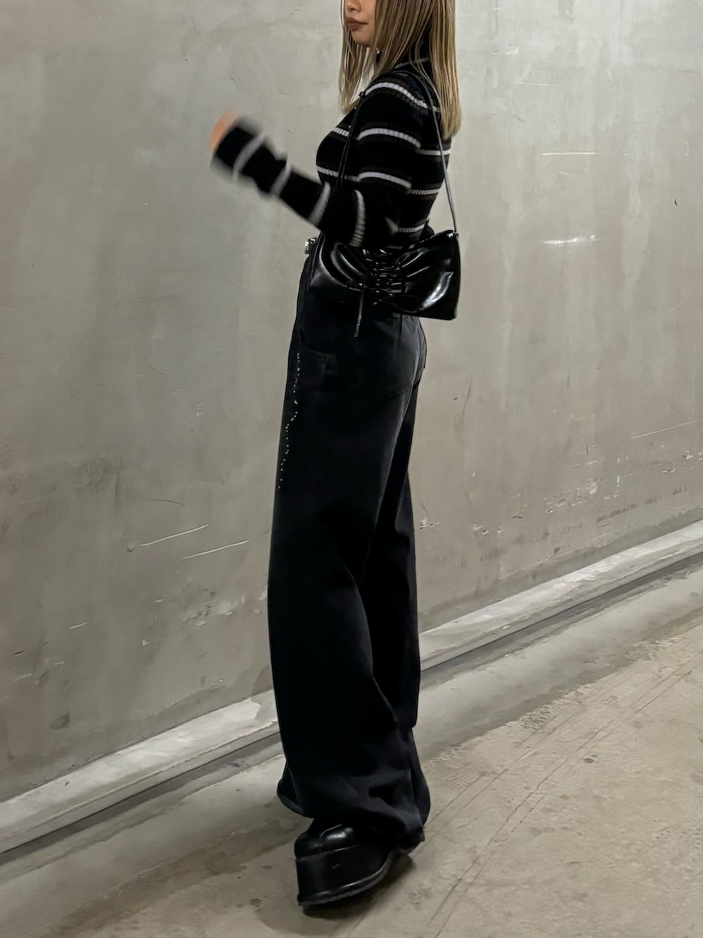 ブラック系のデニムパンツ、その他のニット/セーター、ブラック系のショルダーバッグを着用したレディースの秋コーディネートの2枚目の写真