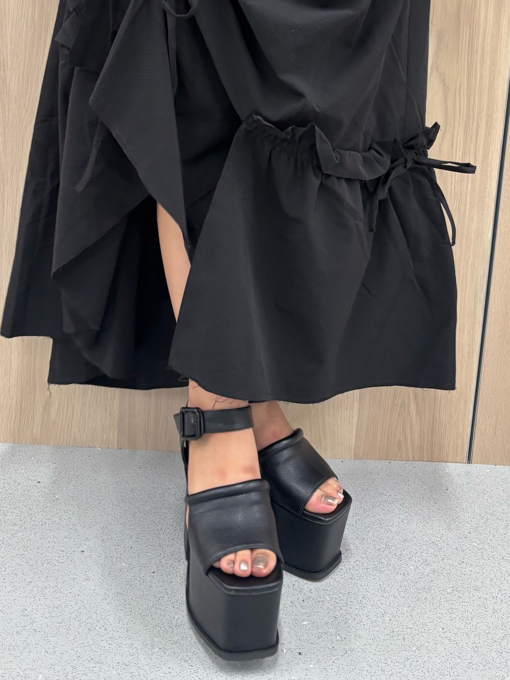 ブラック系のワンピース、ホワイト系のシャツ/ブラウス、ブラック系のサンダルを着用したレディースの春コーディネートの7枚目の写真