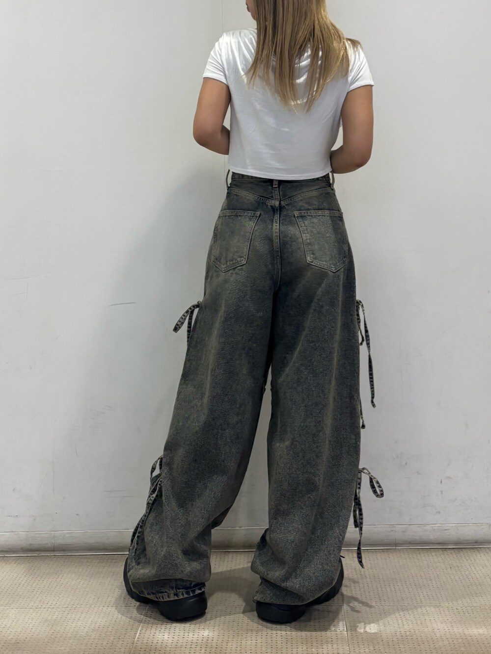 ホワイト系のTシャツ/カットソー、ブルー系のデニムパンツ、ブラック系のスニーカーを着用したレディースの夏コーディネートの3枚目の写真