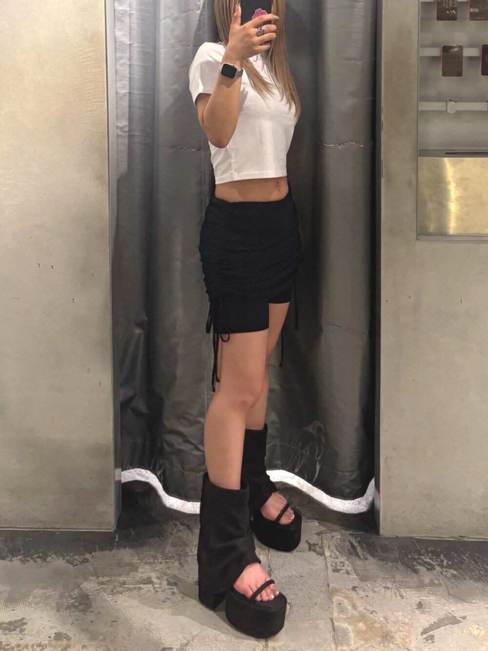 ブラック系のサンダル、ホワイト系のTシャツ/カットソー、ブラック系のスカートを着用したレディースの夏コーディネートの2枚目の写真