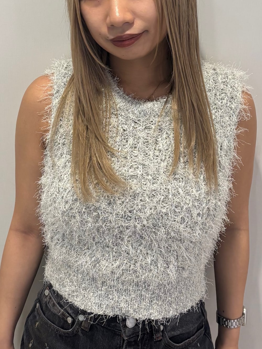 ブラック系のパンプス、ブラック系のデニムパンツ、グレー系のニット/セーターを着用したレディースの春コーディネートの4枚目の写真