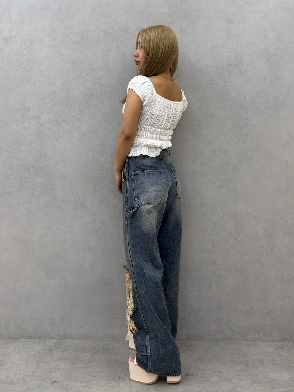 ホワイト系のTシャツ/カットソー、ブルー系のデニムパンツ、ホワイト系のサンダルを着用したレディースの春コーディネートの2枚目の写真
