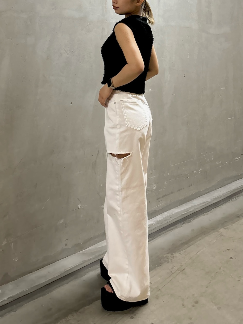 ブラック系のタンクトップ、ホワイト系のデニムパンツ、ブラック系のサンダルを着用したレディースの夏コーディネートの2枚目の写真