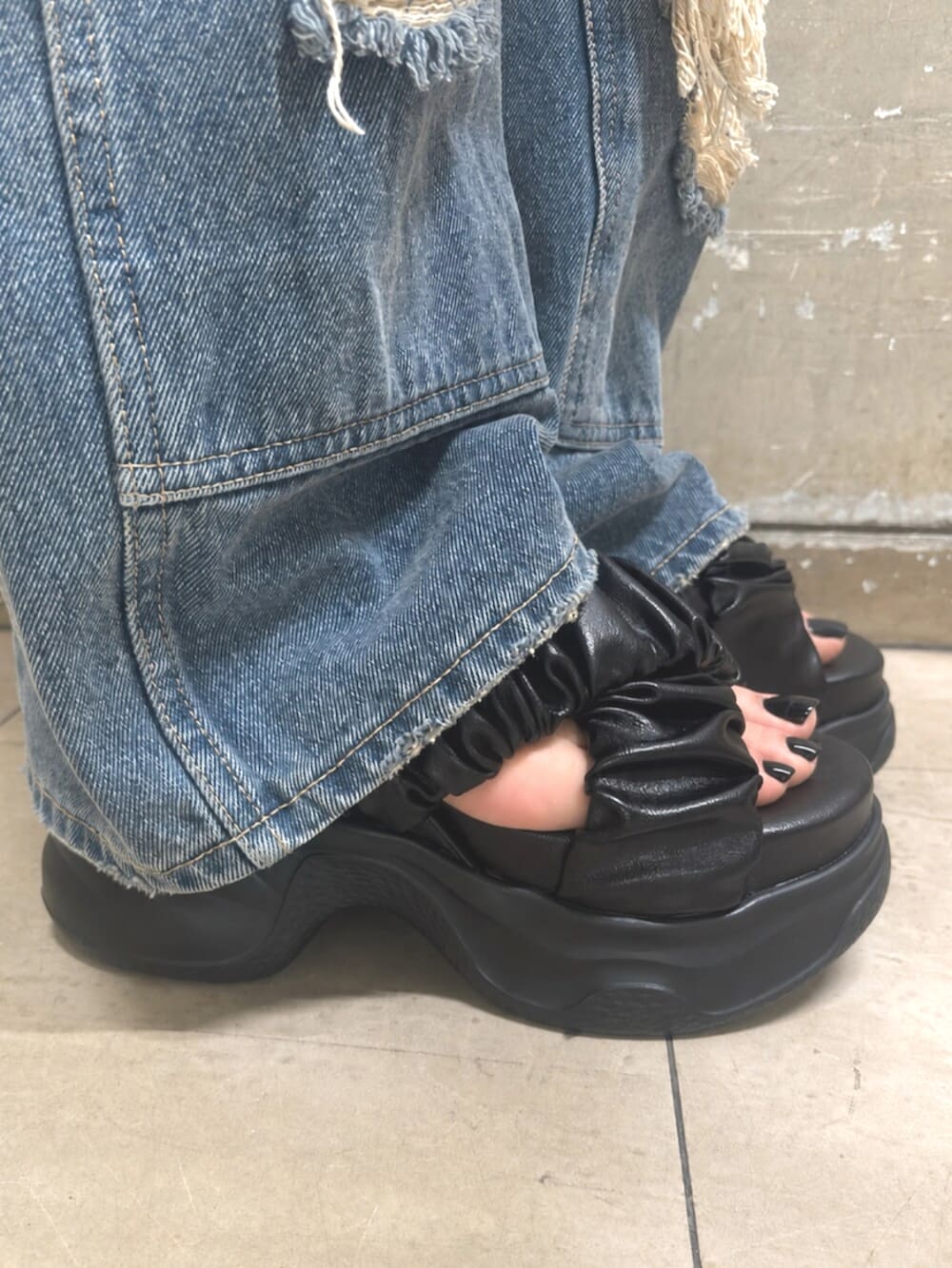 ブルー系のデニムパンツ、ブラック系のニット/セーター、ブラック系のサンダルを着用したレディースの夏コーディネートの5枚目の写真