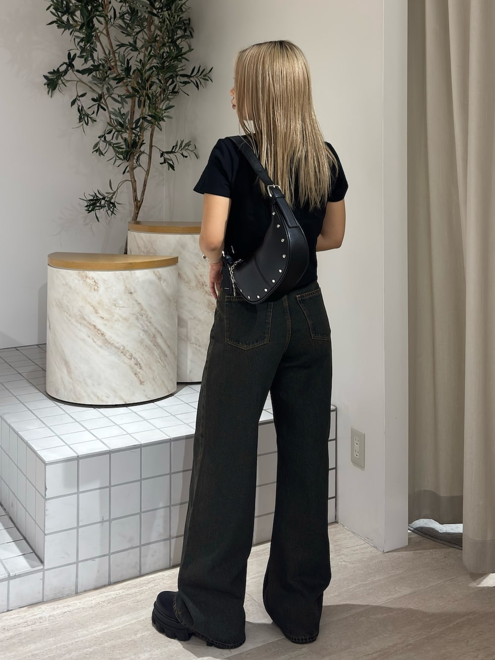 ブラック系のTシャツ/カットソー、ブルー系のデニムパンツ、ブラック系のブーツを着用したレディースの春コーディネートの3枚目の写真