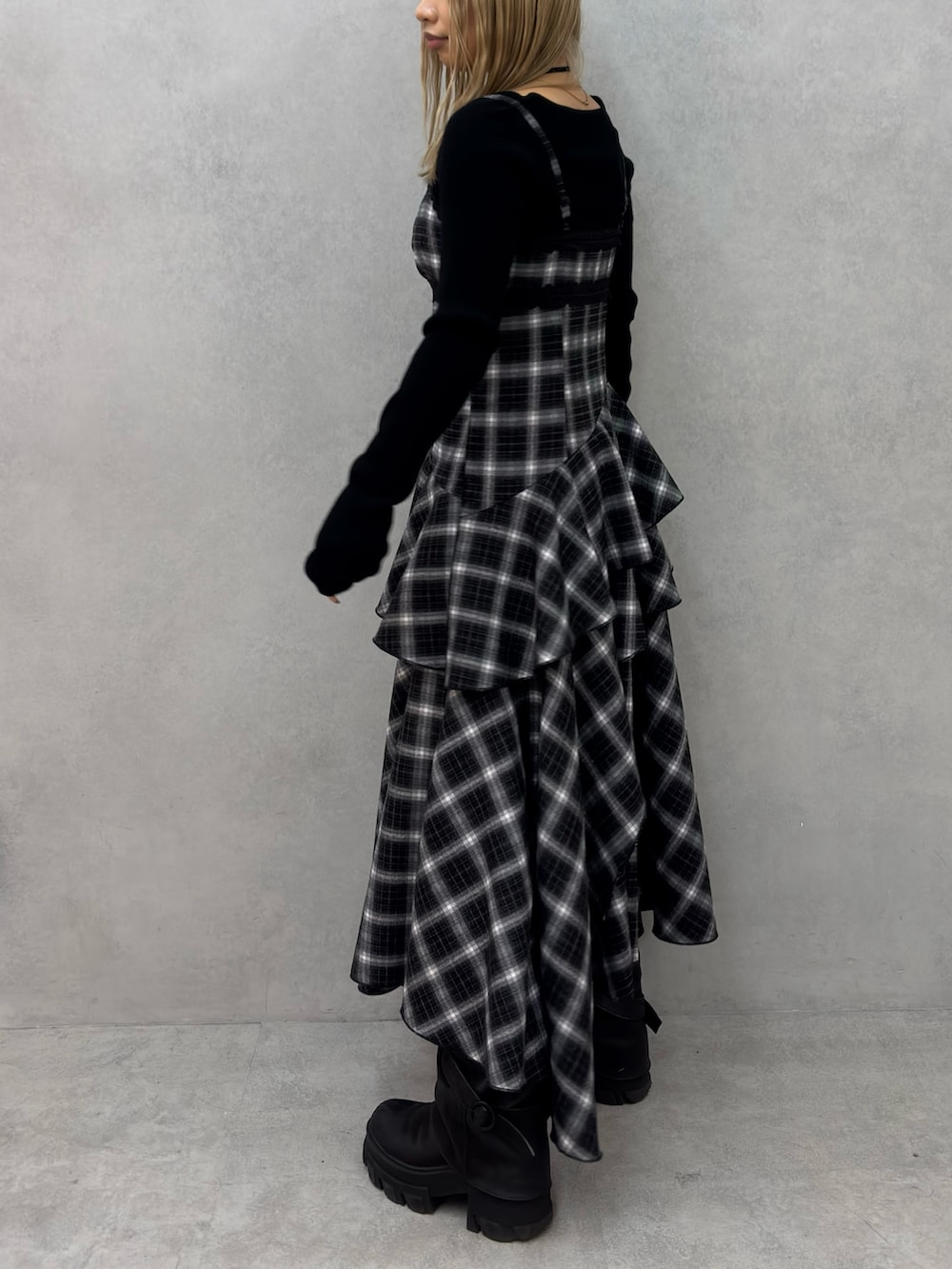 ブラック系のブーツ、ブラック系のワンピース、ブラック系のニット/セーターを着用したレディースの冬コーディネートの2枚目の写真