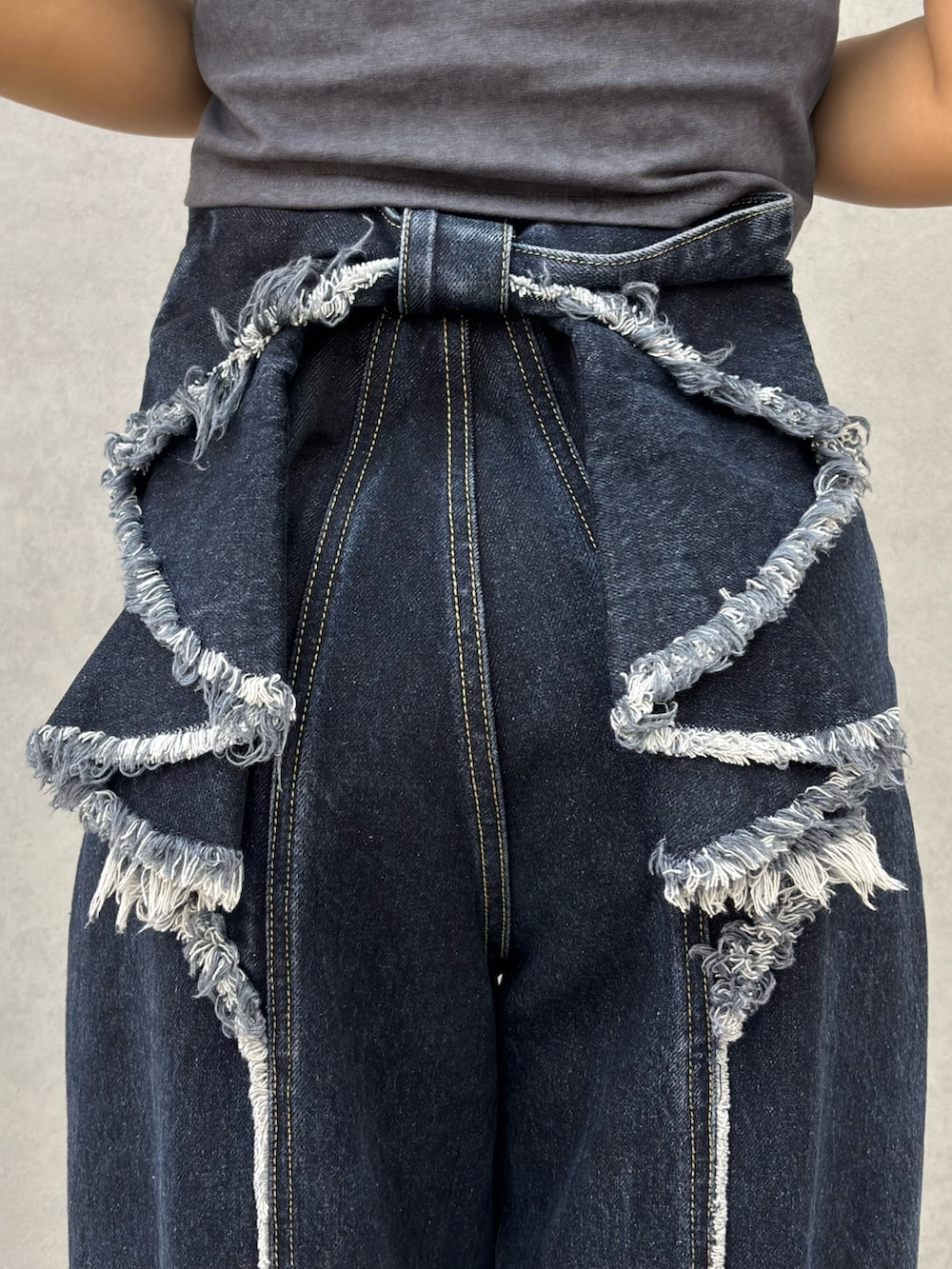 グレー系のTシャツ/カットソー、ブルー系のデニムパンツ、ブラック系のサンダルを着用したレディースの春コーディネートの5枚目の写真