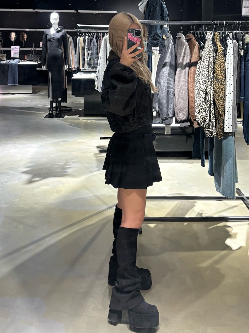 ブラック系のブルゾン、ブラック系のスカート、ブラック系のブーツを着用したレディースの秋コーディネートの2枚目の写真