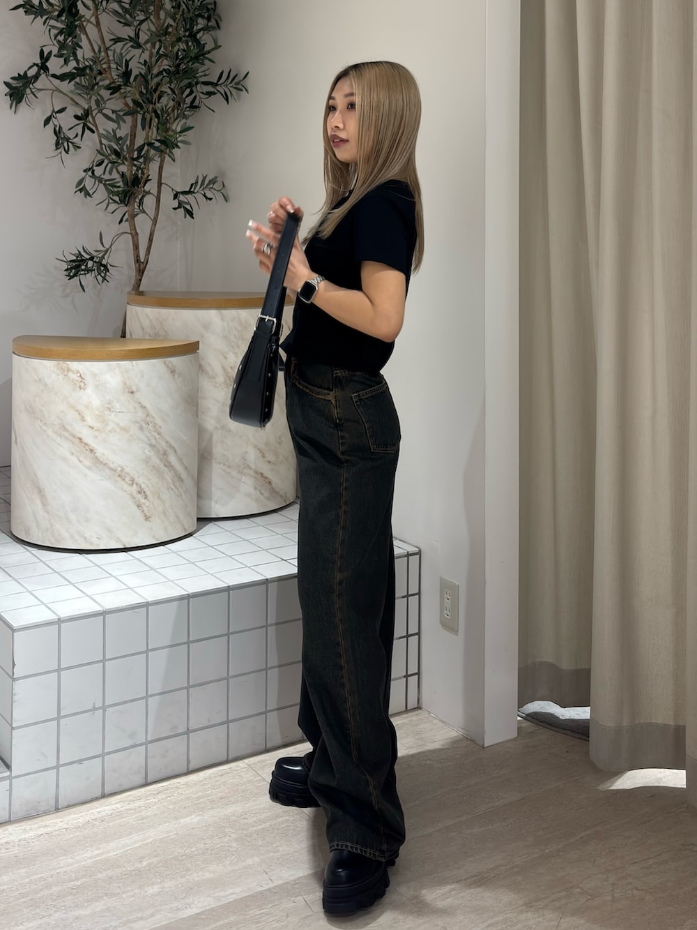 ブラック系のTシャツ/カットソー、ブルー系のデニムパンツ、ブラック系のブーツを着用したレディースの春コーディネートの2枚目の写真