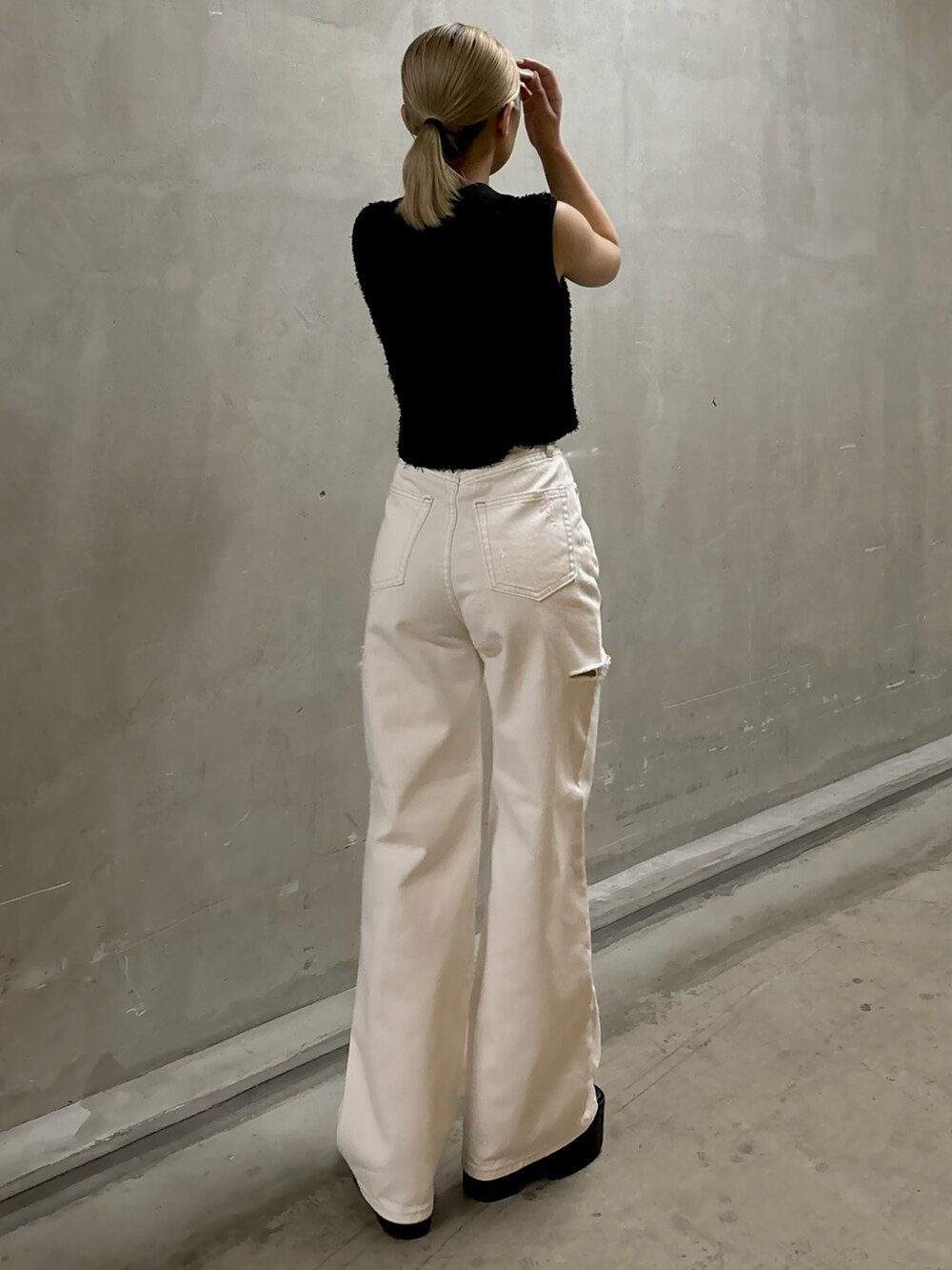 ブラック系のタンクトップ、ホワイト系のデニムパンツ、ブラック系のサンダルを着用したレディースの夏コーディネートの3枚目の写真