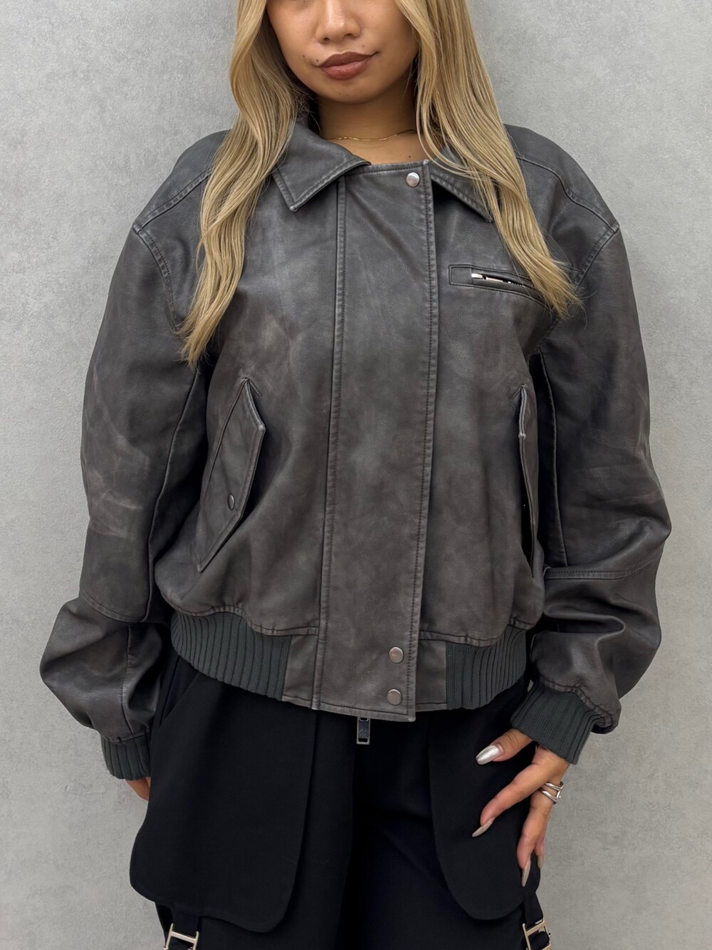 グレー系のブルゾン、ブラック系のその他パンツ、ブラック系のブーツを着用したレディースの秋コーディネートの4枚目の写真