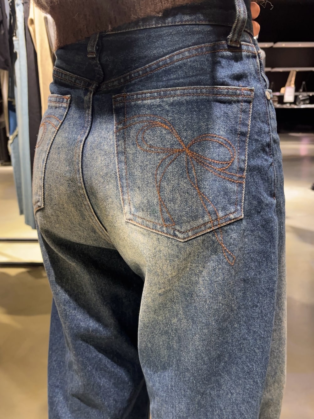 ブラウン系のニット/セーター、ブルー系のデニムパンツ、ブラック系のブーツを着用したレディースの秋コーディネートの5枚目の写真