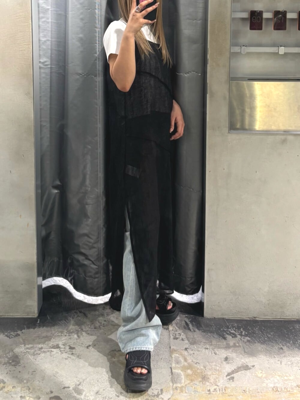 ブラック系のサンダル、ブラック系のワンピース、ホワイト系のTシャツ/カットソーを着用したレディースの夏コーディネートの2枚目の写真