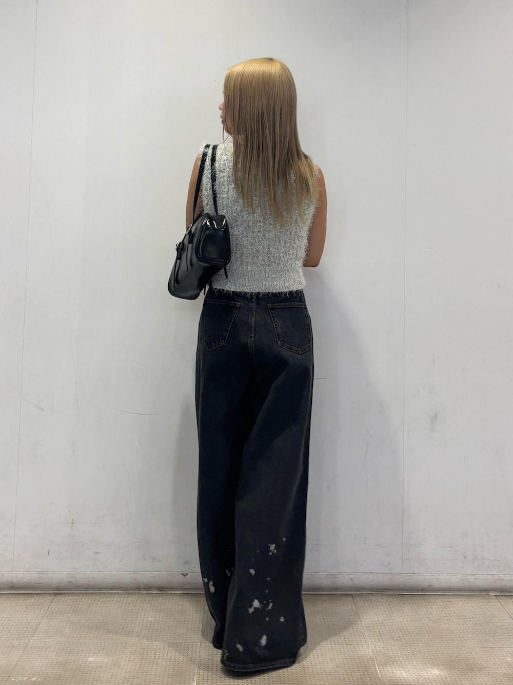 ブラック系のパンプス、ブラック系のデニムパンツ、グレー系のニット/セーターを着用したレディースの春コーディネートの3枚目の写真