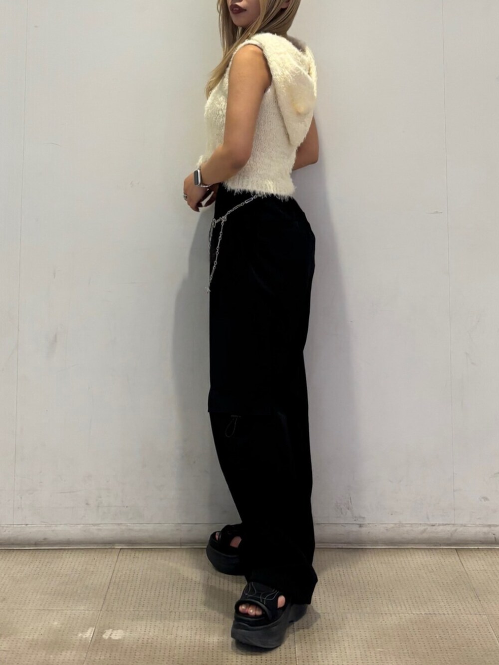 ホワイト系のニット/セーター、ブラック系のその他パンツ、ブラック系のサンダルを着用したレディースの春コーディネートの2枚目の写真