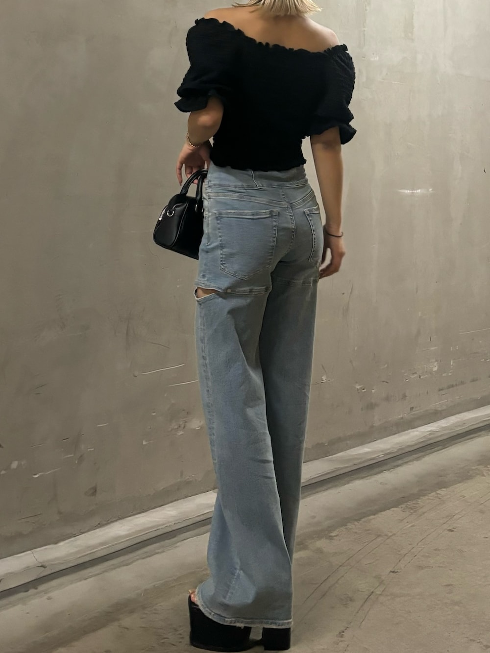ブラック系のTシャツ/カットソー、ブルー系のデニムパンツ、ブラック系のハンドバッグを着用したレディースの春コーディネートの3枚目の写真