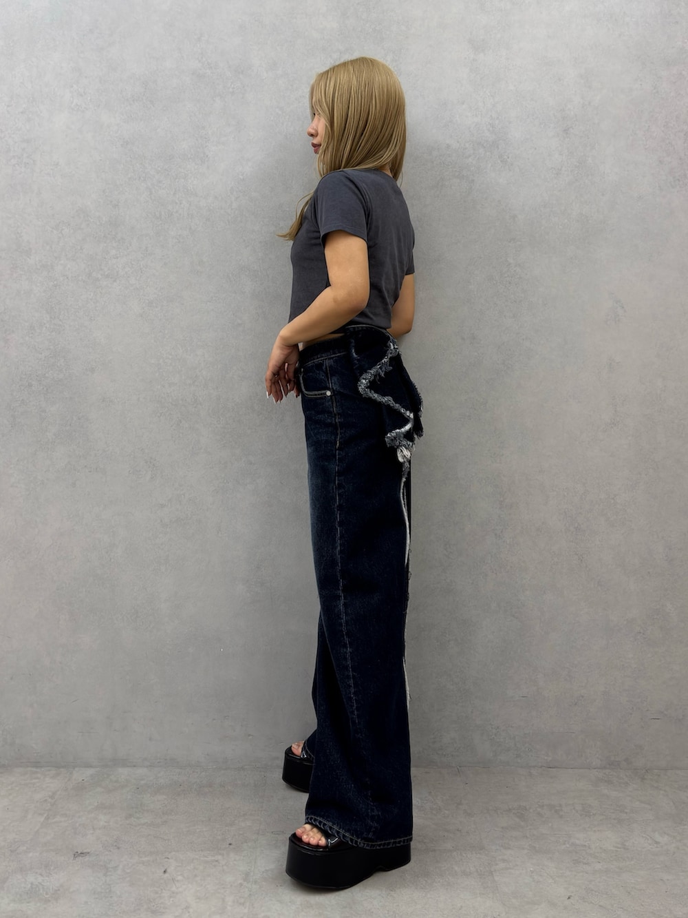 グレー系のTシャツ/カットソー、ブルー系のデニムパンツ、ブラック系のサンダルを着用したレディースの春コーディネートの2枚目の写真