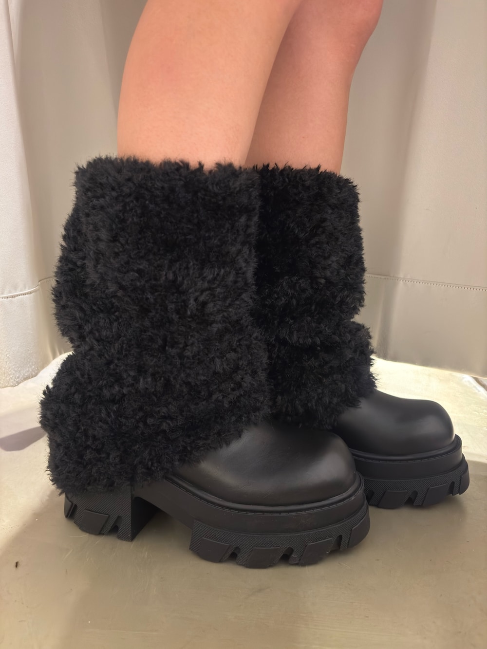 ブルー系のニット/セーター、ブラック系のその他パンツ、ブラック系のブーツを着用したレディースの冬コーディネートの5枚目の写真