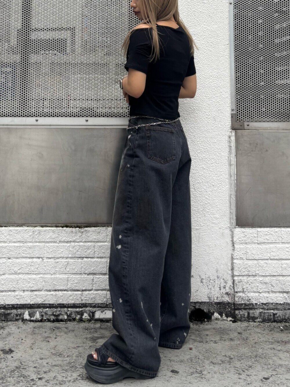 ブラック系のサンダル、ブラック系のTシャツ/カットソー、ブラック系のデニムパンツを着用したレディースの春コーディネートの2枚目の写真