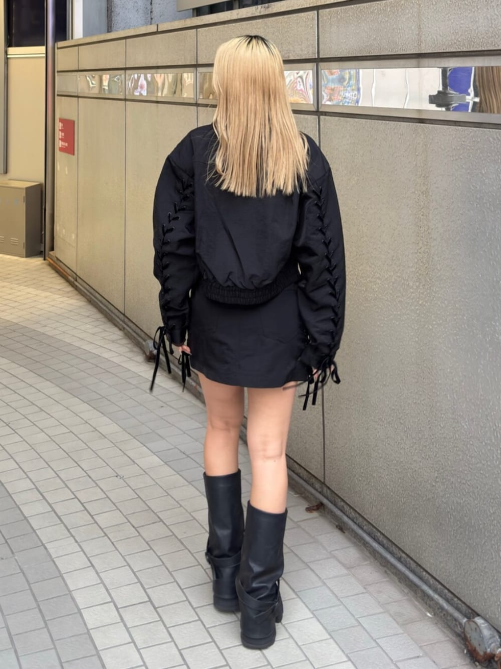 ブラック系のブーツ、ブラック系のスカート、ブラック系のブルゾンを着用したレディースの冬コーディネートの3枚目の写真