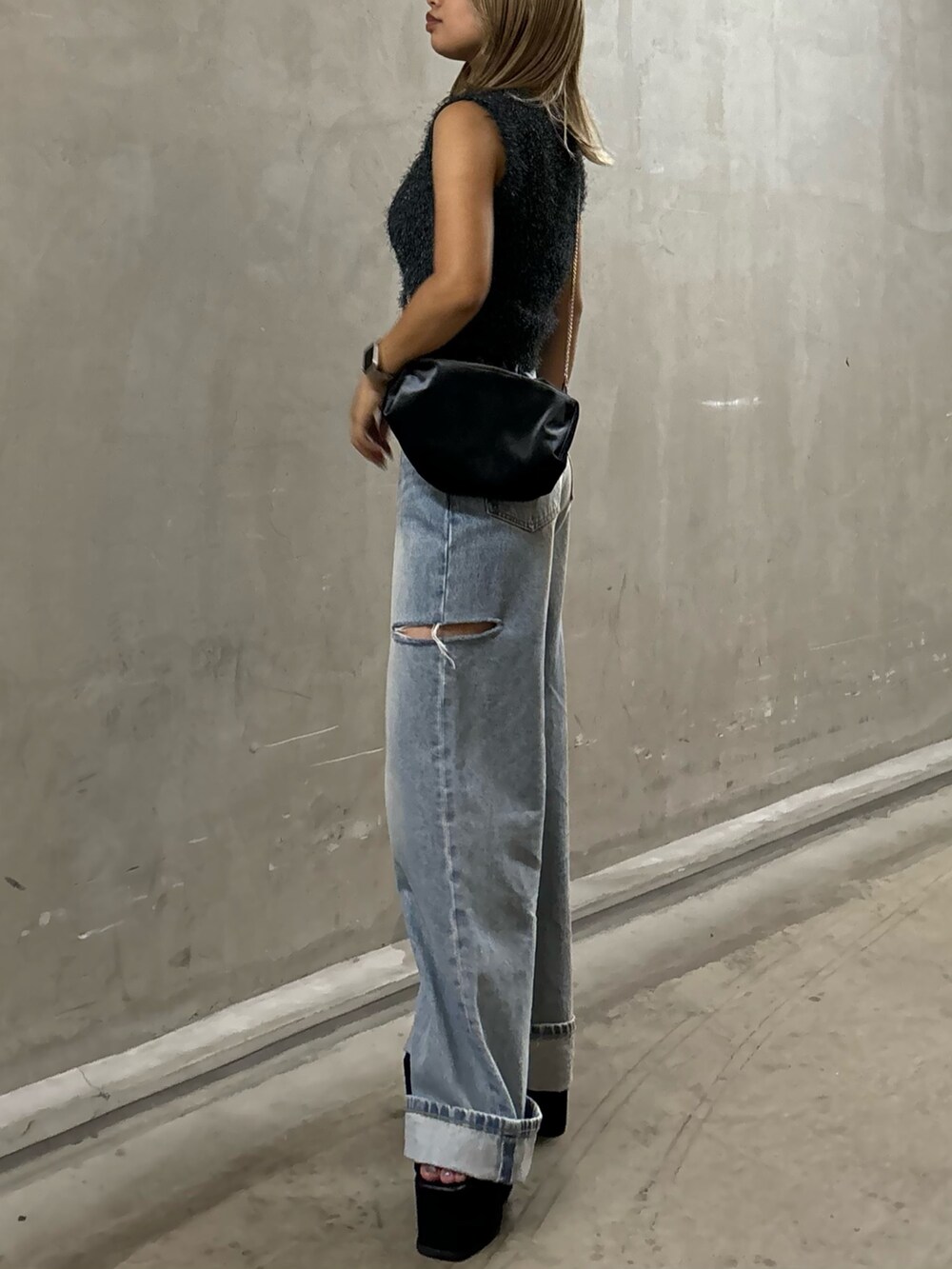 ブルー系のデニムパンツ、グレー系のタンクトップ、グレー系のハンドバッグを着用したレディースの夏コーディネートの2枚目の写真