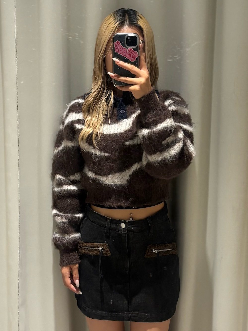 ブラウン系のニット/セーター、ブラック系のスカート、ブラック系のブーツを着用したレディースの秋コーディネートの4枚目の写真