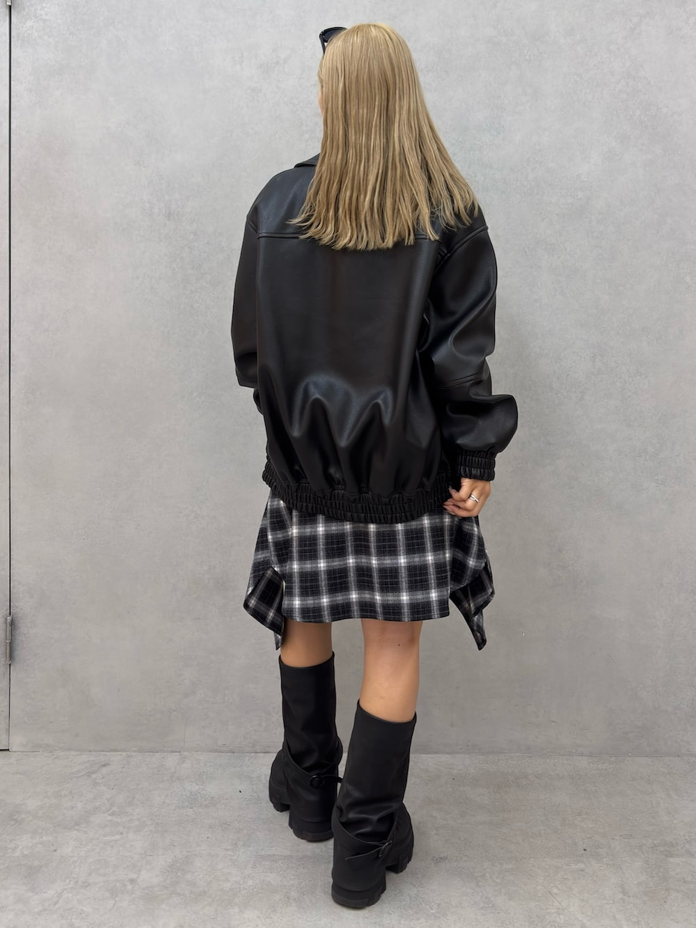 グレー系のニット/セーター、ブラック系のブルゾン、ブラック系のシャツ/ブラウスを着用したレディースの冬コーディネートの3枚目の写真